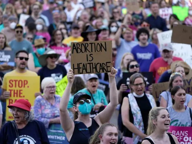 Abortion-rights protesters cheer at a rally following the United States Supreme Court's decision to overturn Roe v. Wade, federally protected right to abortion, outside the state capitol in Lansing, Michigan, Friday, June 24, 2022.