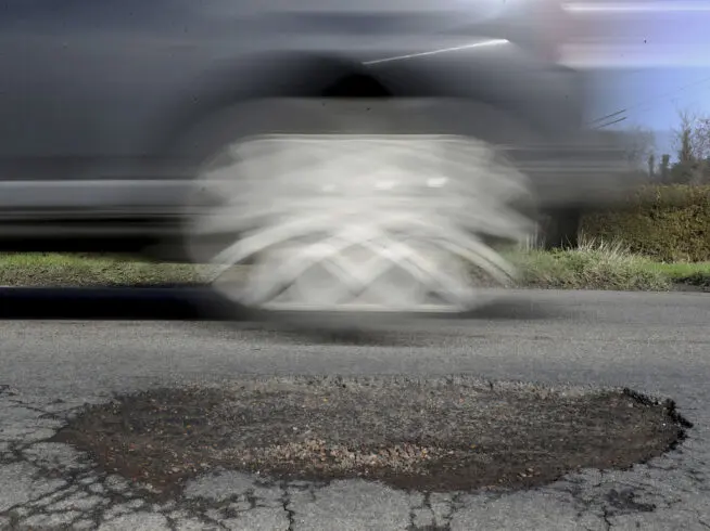 File photo of a car passing a pothole.