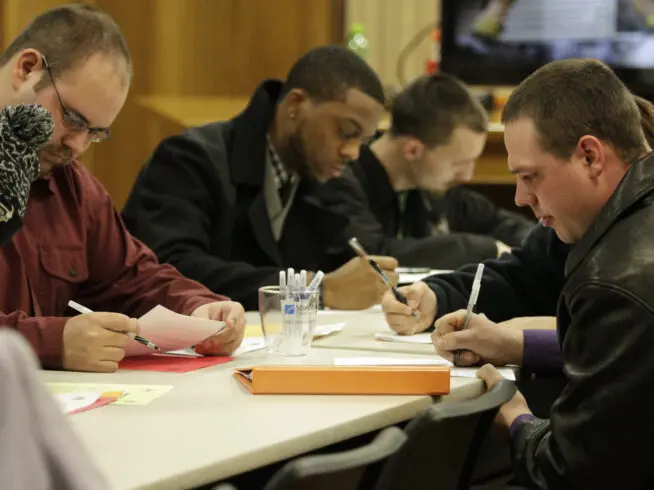 In this Jan. 29, 2015 photo, people fill out applications during a public safety job fair at City Hall in Saginaw, Michigan.