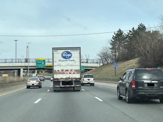 Rear view of a Kroger semi-truck and two other cars on the Interstate 94 along I-94 approaching the John C Lodge Freeway (M-10) in Detroit, Michigan.