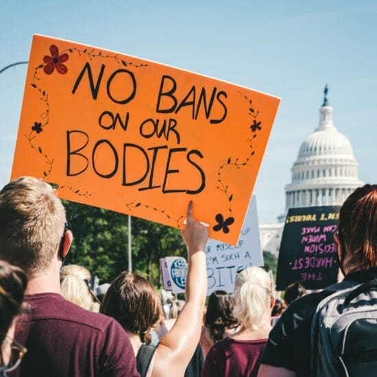 People holding signs in front of the U.S. Capitol in Washington, D.C., on Oct. 3, 2021. Sign in the foreground says: No Bans on our Bodies.