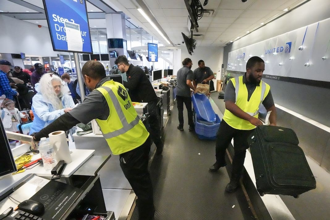 Agents check-in passengers and their baggage at George Bush Intercontinental Airport on Dec. 21, 2023, in Houston. On Friday, the U.S. government issues its December jobs report. (Brett Coomer/Houston Chronicle via AP, File)