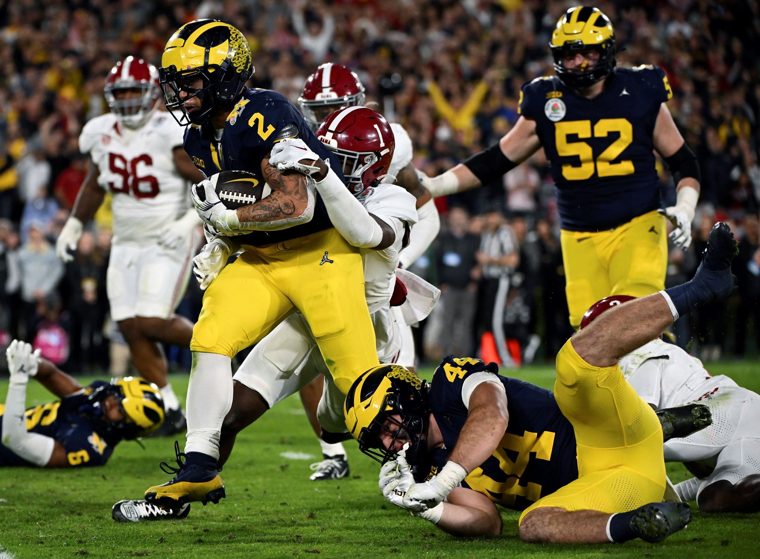 Michigan running back Blake Corum (2) runs in for a touchdown past Alabama defensive back Kool-Aid McKinstry (1) during overtime at the Rose Bowl CFP NCAA semifinal college football game Jan. 1, 2024, in Pasadena, CA